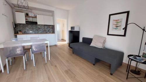ein Wohnzimmer mit einem Sofa und einem Tisch sowie eine Küche in der Unterkunft Arco Home in Arco