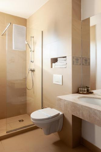 a bathroom with a shower and a toilet and a sink at Hotel Victoria in Eforie Nord