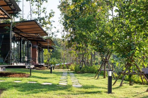 a garden with stepping stones in front of a house at Huaysompoi Valley Nan in Nan