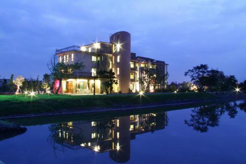 a building next to a river at night at Full Sweet Inn in Wujie