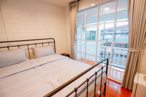 a bedroom with a bed and a large window at Chertel Poshtel in Ban Chamun (2)