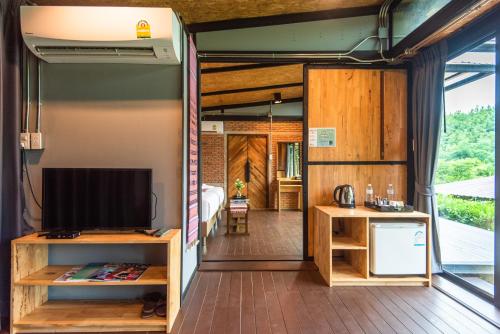 Una habitación con televisión y una sala de estar. en Huaysompoi Valley Nan, en Nan