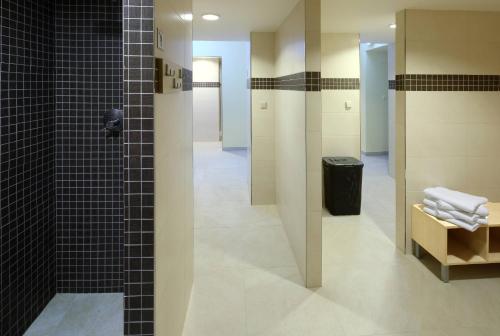 a bathroom with a shower with black tiles and a toilet at WINDSOR SPA Hotel in Karlovy Vary