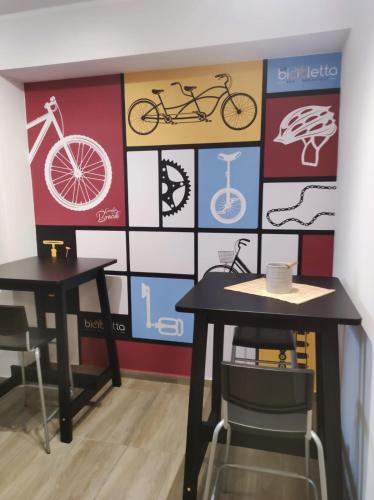 two tables and chairs in front of a wall with bikes at b&b La Bicicletta in Rende