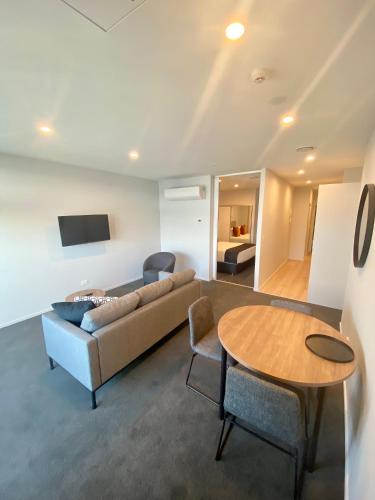 a living room with a couch and a table at Ramada by Wyndham Newmarket Auckland in Auckland