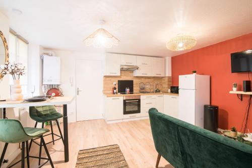 Il comprend une cuisine équipée d'un réfrigérateur blanc et de chaises vertes. dans l'établissement Nouveau - L'Hacienda - Hyper Centre, à Haguenau