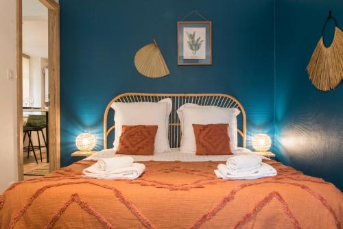 Un dormitorio azul con una cama con toallas. en Nouveau - L'Hacienda - Hyper Centre en Haguenau