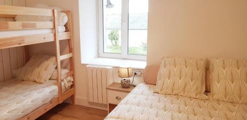 a bedroom with two bunk beds and a window at Les 3 mômes in Pontorson