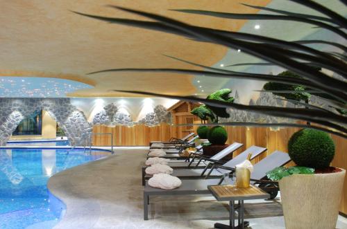 a hotel lobby with a pool and a row of chairs at Sporthotel Rosatti in Dimaro