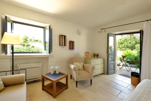 a living room with a couch and a chair and a table at Masseria Trulli e Vigne in Martina Franca