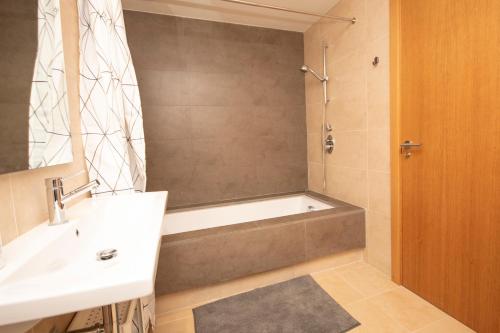 ein Badezimmer mit einer Badewanne und einem Waschbecken in der Unterkunft Where everyone is welcome in Estepona
