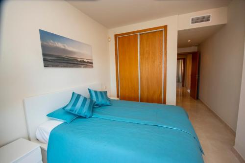 ein blaues Bett mit blauen Kissen im Schlafzimmer in der Unterkunft Where everyone is welcome in Estepona
