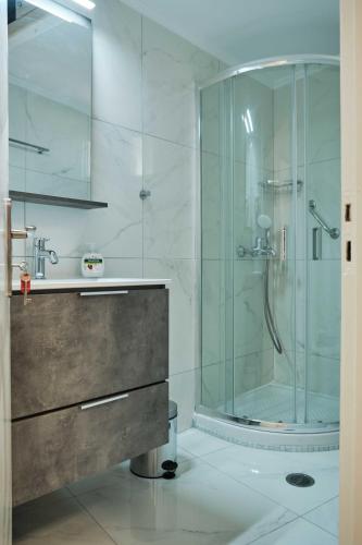 a bathroom with a glass shower and a sink at Panos Apartments in Parga