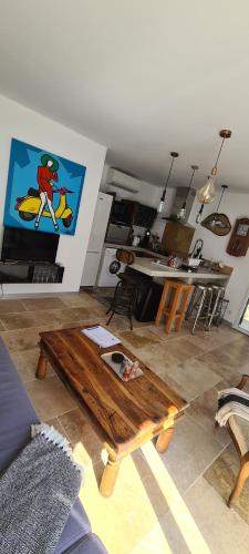 Il comprend un salon doté d'une télévision et d'une table basse en bois. dans l'établissement L'attelu avec piscine au coeur du maquis, à Carbuccia