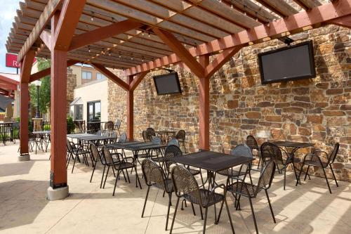 a group of tables and chairs under a wooden pergola at Ramada by Wyndham Fargo in Fargo