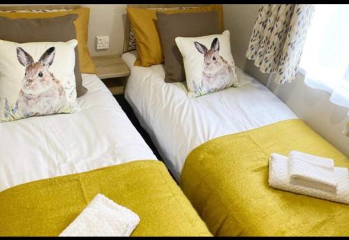 two beds with rabbits pillows on them in a room at Lido leisure park in Knaresborough