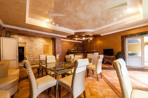 a dining room with a glass table and white chairs at Olga Hotel SPA in Tatariv