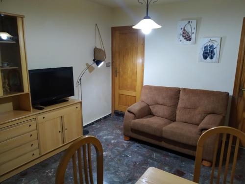 sala de estar con sofá y TV en Casa Rural Celia, en Ayna