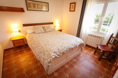 a bedroom with a bed and two chairs and a window at El Bulín de la Cabrera - Pico de la Miel in La Cabrera