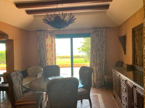 a dining room with a table and chairs and a window at Ras Sedr Royal Beach Villa at Sinaway Lagoon Hotel & Spa- Ras Sedr, Egypt in Ras Sedr