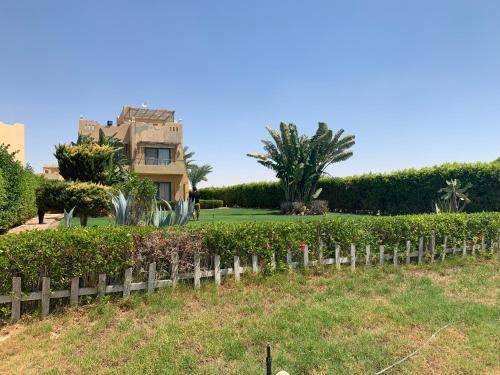a house with a fence in front of a yard at Ras Sedr Royal Beach Villa at Sinaway Lagoon Hotel & Spa- Ras Sedr, Egypt in Ras Sedr