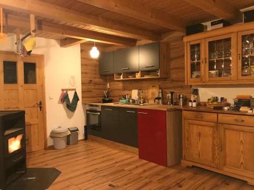 a kitchen with wooden cabinets and a stove top oven at Kletterhütte Sächsische Schweiz in Hohnstein