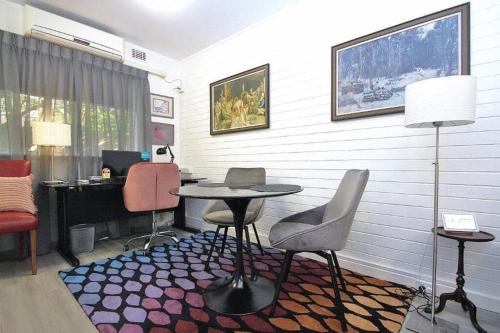 um quarto com uma mesa, cadeiras e uma secretária em LOCATION LIFESTYLE CONVENIENCE! WIFI NETFLIX WINE em Perth