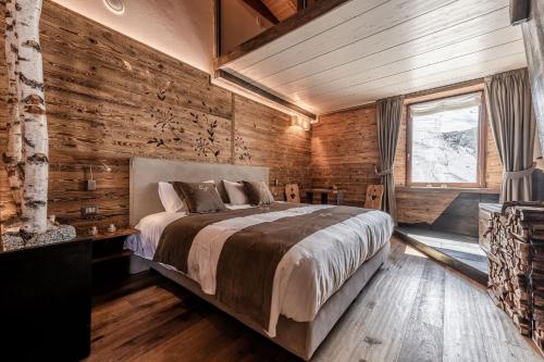 a bedroom with a bed and a wooden wall at CAPANNA PRESENA in Passo del Tonale