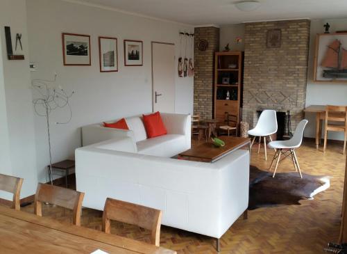 uma sala de estar com um sofá branco e uma mesa em Kapiteinshuis Breskens em Breskens