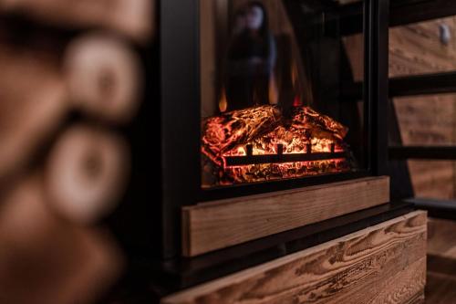 a wood stove with a fire in it at CAPANNA PRESENA in Passo del Tonale