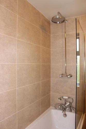 y baño con bañera, ducha y lavamanos. en Woodlands Country House & Cottage, en Ireby