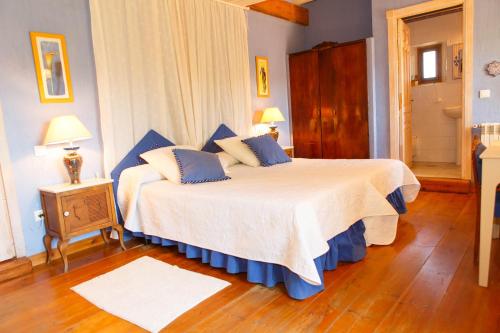 Un dormitorio con una cama con almohadas azules. en El Bulín de Cubillo - Casa del Arcipreste, en Cubillo