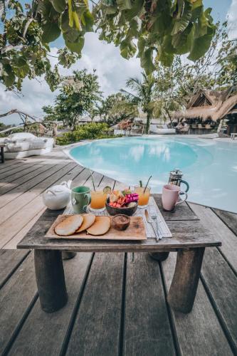 a tray of food on a table next to a pool at La Cabane in Jimbaran