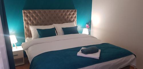 a bedroom with a large bed with blue walls at Apartman Lara in Foča