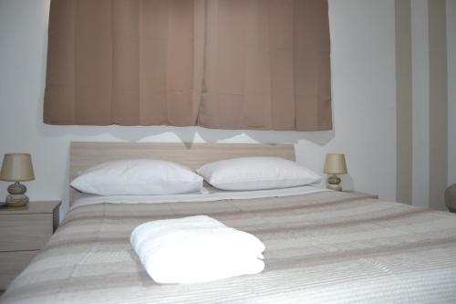 a bed with two white pillows on top of it at Sara Home in Cosenza