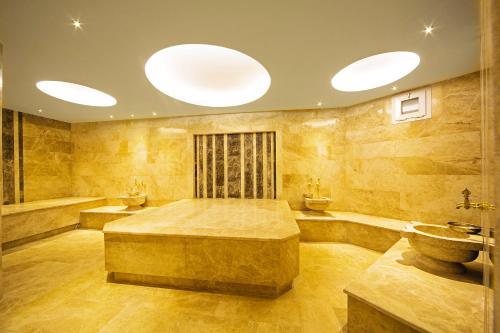 a large bathroom with a bed and a bath tub at Poseidon Hotel - Adult Only in Marmaris