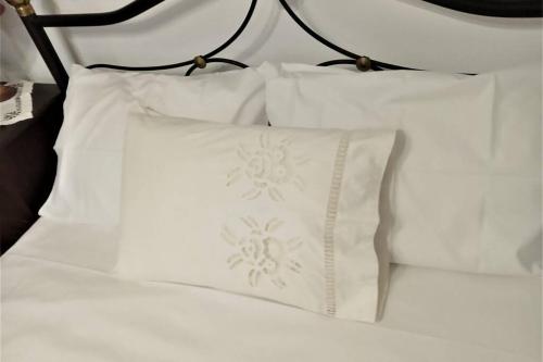 a pile of white pillows sitting on a bed at ΑΝΕΞΑΡΤΗΤΟ STUDIO ΣΤΟ ΟΜΟΡΦΟ ΚΑΣΤΟΡΕΙΟ in Kastórion
