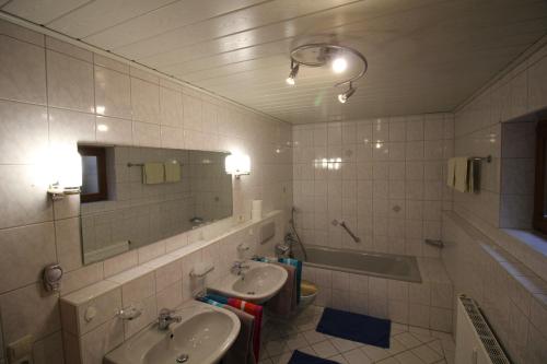 a bathroom with two sinks and a tub and a mirror at Rötenbacher Wiesen in Friedenweiler