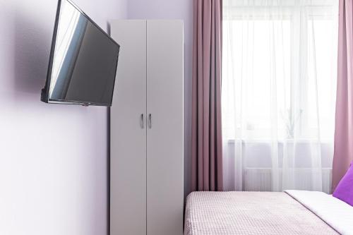 モスクワにあるУютные апартаментыのベッドルーム1室(ベッド1台、壁にテレビ付)