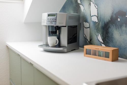 a coffee machine sitting on a counter with a box at Moderne Ferienwohnung mit Südbalkon in der Nähe der Stever in Lüdinghausen