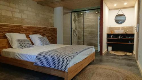 a bedroom with a bed and a glass shower at Moulin de Vibrac in Vibrac