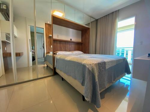 um quarto com uma cama e uma parede de vidro em VG Fun Residence Praia do Futuro em Fortaleza