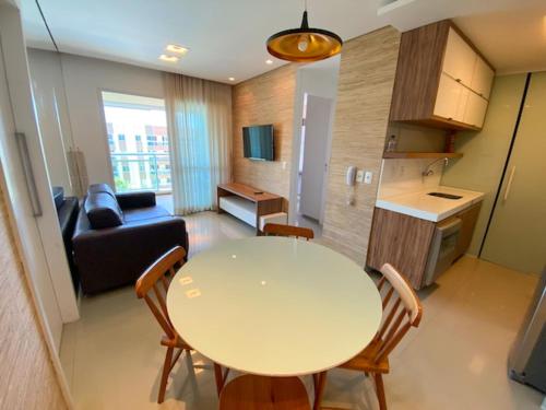 uma cozinha e uma sala de estar com mesa e cadeiras em VG Fun Residence Praia do Futuro em Fortaleza