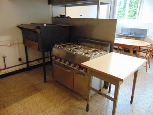 une cuisine avec une cuisinière et une table à l'intérieur dans l'établissement Les Morillons, à Foncine-le-Bas