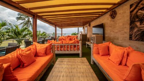 a porch with orange pillows and chairs on a balcony at Jumeirah Beachfront in Mombasa