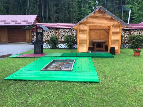 a wooden cabin with a picnic table in a yard at Olga Hotel SPA in Tatariv