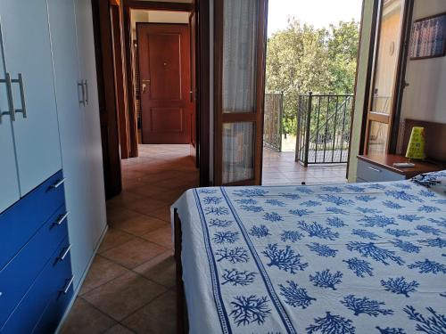 a bedroom with a bed with a blue and white blanket at Holiday in SARDINIA in Pula, at the sea of ​​Nora in Pula