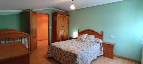 1 dormitorio con 1 cama y paredes verdes en Apartamentos Casa Alvarina - Luarca, en Cortina