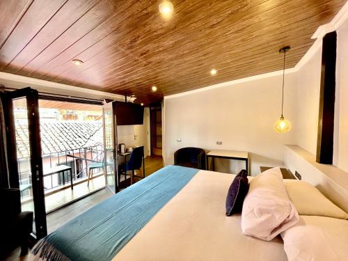 a bedroom with a bed and a large window at Casa Montes San Blas in Cusco