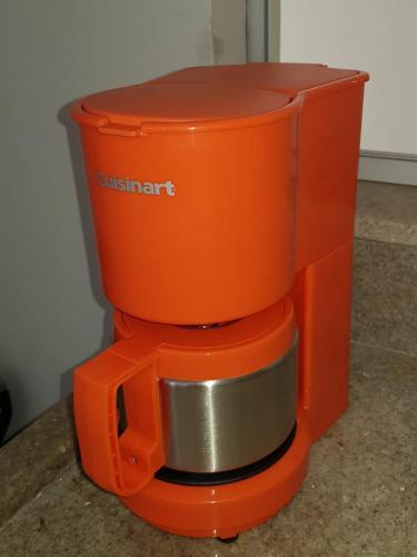 an orange coffee maker sitting on top of a counter at Sobrado 4 amplo e confortável em condomínio in Corumbá